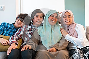 Middle eastern family portrait single mother with teenage kids at home in living room. Selective focus