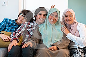 Middle eastern family portrait single mother with teenage kids at home in living room. Selective focus