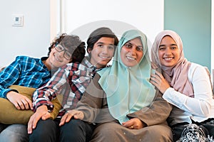 Middle eastern family portrait single mother with teenage kids at home in living room. Selective focus