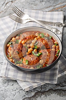 Middle Eastern Lamb meatballs with chickpeas in tomato sauce close-up in a bowl. Vertical