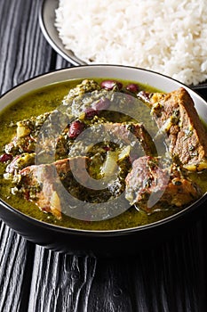 Middle Eastern lamb stew meat with herbs and beans close-up in a bowl and rice. vertical