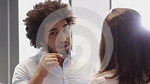 Middle Eastern Man having a conversation with female colleague in office