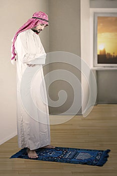 Middle eastern man praying at home