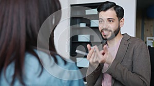 Middle Eastern man talking to female colleague discussing business in office