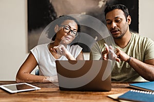 Middle eastern man and woman working with laptop together