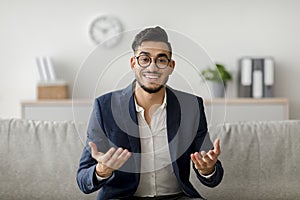 Middle Eastern Psychologist Smiling and Gesturing During a Counseling Session in Office
