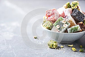 Middle Eastern sweets. Turkish delight with pistachios nuts on grey background. Copy space. Arab dessert, rahat lokum