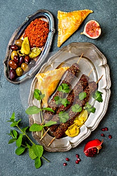 Middle Eastern traditional dinner. Authentic arab cuisine. Meze party food. Lamb kebab, sambusek, muhammara.