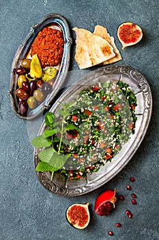 Middle Eastern traditional dinner. Authentic arab cuisine. Meze party food. Tabbouleh, muhammara, olives.