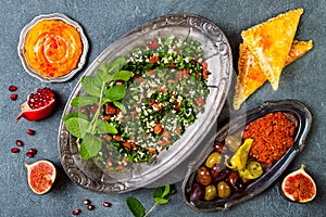 Middle Eastern traditional dinner. Authentic arab cuisine. Tabbouleh, sambusek, muhammara, pumpkin hummus.