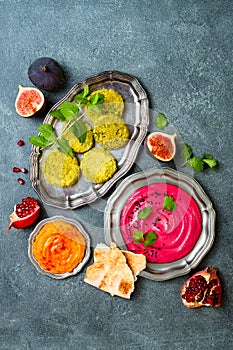 Middle Eastern traditional food. Authentic arab cuisine. Vegan green baked falafel, roasted beet and pumpkin hummus.