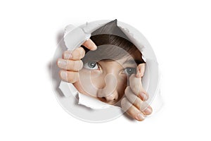 Middle eastern woman peeking from ripped white paper hole