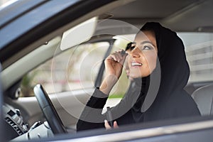 Middle Eastern Women Sitting Inside a Car and Applying Make-up