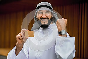 Middle eastern young man holding a credit card