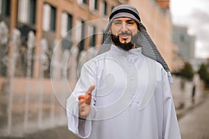 Middle eastern young man strecthing his hand for a handshake