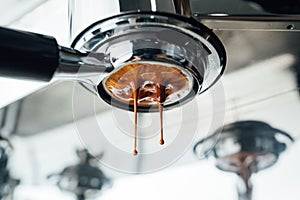 Middle of the process of extracting espresso from bottomless portafilter photo