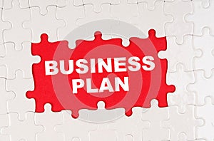 In the middle of the puzzles on a red background it is written - BUSINESS PLAN