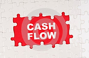 In the middle of the puzzles on a red background it is written - CASH FLOW