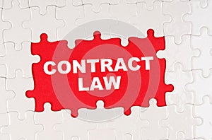 In the middle of the puzzles on a red background it is written - CONTRACT LAW