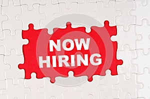 In the middle of the puzzles on a red background it is written - NOW HIRING