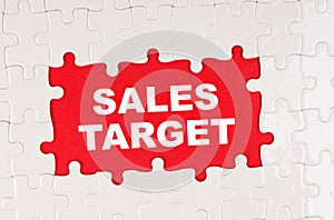 In the middle of the puzzles on a red background it is written - SALES TARGET