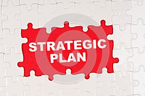 In the middle of the puzzles on a red background it is written - STRATEGIC PLAN