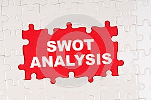 In the middle of the puzzles on a red background it is written - SWOT ANALYSIS
