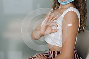 Middle seceltion of woman getting vaccinated immunity giving ok sign hand. Concept of recommended inoculation. Female