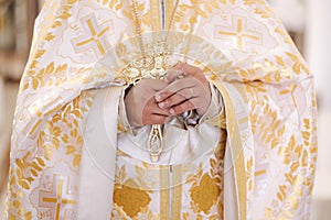 Middle selection of the priest holds a cross in his hands