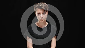 Middle shot portrait of sad humiliated young woman posing at black background. Frustrated Caucasian brunette lady