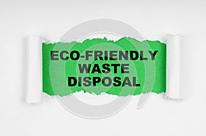 In the middle of the white sheet, the paper is torn, inside on a green background the inscription - Eco-friendly waste disposal photo