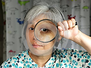 middleage woman holding magnifier