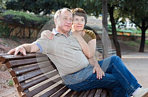Middleaged male and female posing on bench