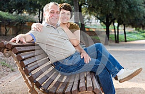 Middleaged male and female posing on bench