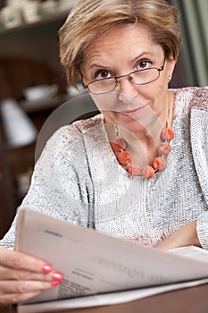 Middleaged woman reading newspaper