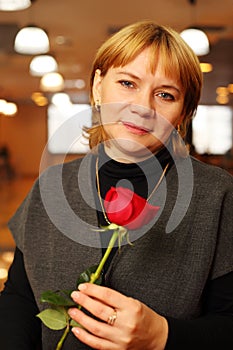 Middleaged woman with rose in hands