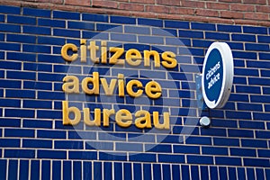 Citizens Advice Bureau sign in yellow and blue on brick wall