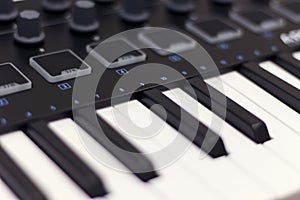 Midi keyboard is white close-up. Modern electronic music, studio equipment.