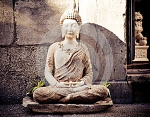 The miditation sculpture with the money in front of a restaurant