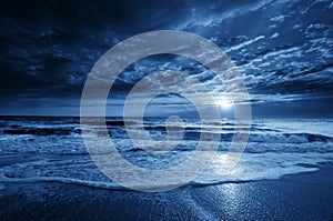 Midnight Blue Coastal Moonrise With Dramatic Sky and Rolling Waves