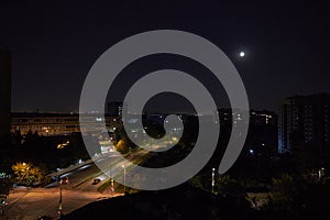 Midnight moon over a city intersection