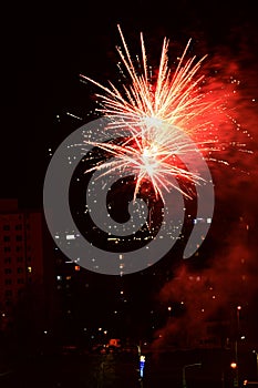 Midnight red coloured New Year fireworks with smoke in background, fired above Nitra residental part during New Year celebration.