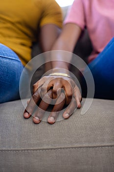 Midsection of african american couple hands holding hands at home photo