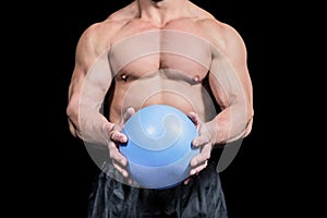 Midsection of bodybuilder exercising with ball