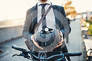 Midsection of businessman commuter with electric bicycle traveling from work in city.