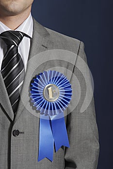 Midsection Of Businessman Wearing Blue Ribbon On Lapel photo