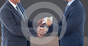 Midsection of businessmen holding money representing corruption concept