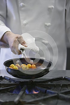 Midsection Of Chef Cooking Food photo