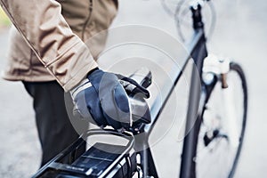 A midsection of a cyclist with electrobike standing outdoors in town.