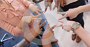 Midsection of diverse businesswomen forming star together with fingers at office, slow motion